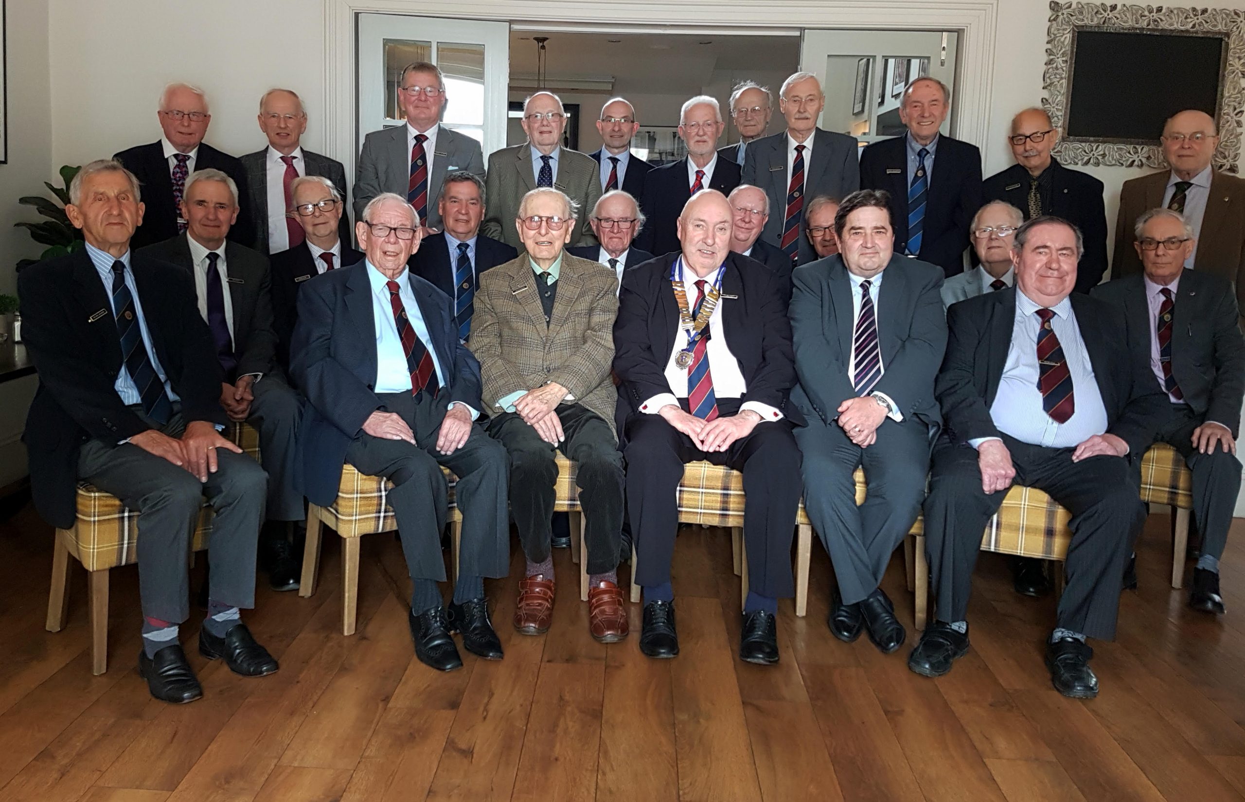 Back row standing left to right: Peter Clark, Malcolm Lynn, Andrew Holmes, Brian Thomas, Gerry Pye, Tony Catterick, Stephen Setchell, Roger Bayley, Colin Holdaway, Nick Martensz, Alex Alexander. Middle row seated left to right: Ian Stott, Peter Blake, Richard Barnett, Michael Barry, Ian Bates, Tony Pepper, Alan Webb, Bryan Basketter. Front row seated left to right: Peter Joyner, Cyril Bainbridge, David Heading, Michael Burnham (President), Graeme Gribben, Chris Hall. Photograph taken on 5th April 2022